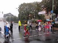 3  Die Schülerinnen und Schüler der Klasse 1a werden von ihrer Klassenlehrerin Frau Scheltens bei Nieselregen über die Straße geführt